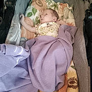 Nevaeh joined the competition — help win amazing prizes! baby, infant, child, sleeping, stroller, blanket, swaddled, lavender, clothing, portrait, face, head, indoors, cozy, textile, floral_pattern, seated, calm, newborn, photography