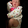 Nevaeh is registered to the contest to win money with this photo: newborn, baby, sleeping, portrait, face, closed_eyes, infant, onesie, polka_dots, blanket, bundled, indoors, dark_background, resting, peaceful, cute, photography, head, hand, knee