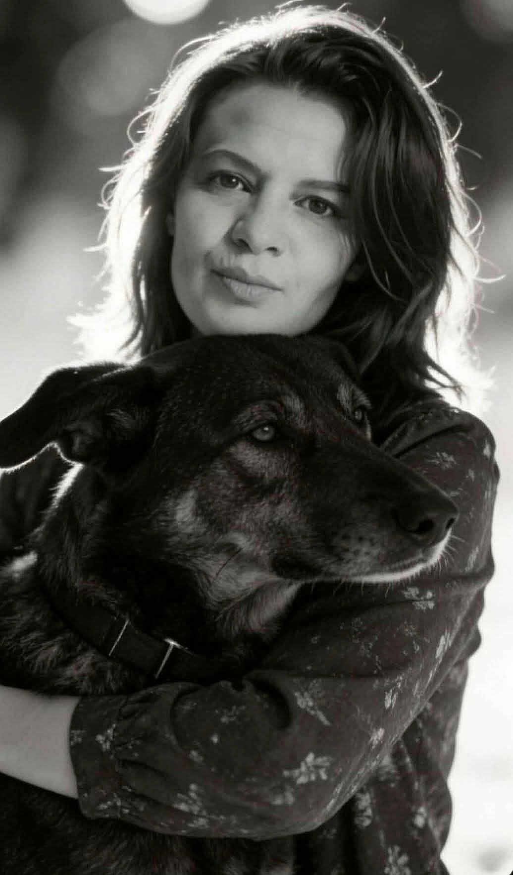 Dimi participe au concours pour gagner de l'argent avec cette photo : affectionate, black_and_white, bokeh, calm, close_up, collar, companion, dog, eyes, face, fur, hair, hug, natural_light, outdoor, pet, photography, portrait, sleeve, woman