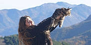 Over participe au concours pour gagner de l'argent avec cette photo : person, girl, cat, long_haired_cat, outdoors, mountains, landscape, sky, sunlight, hair, whiskers, fur, holding, lifted, portrait, happy, scenic, nature, playful, leisure