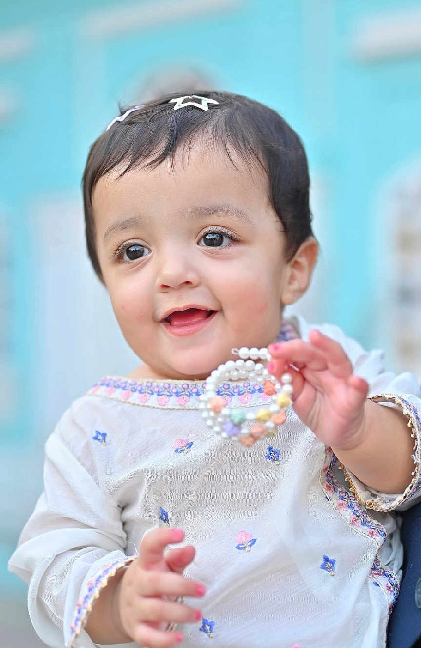 Ayzal Chaudhry is registered to the contest to win money with this photo: toddler, child, smiling, face, hand, jewelry, bracelet, beads, clothing, embroidered, hair_clip, cute, portrait, happy, person, baby, fashion, colorful, background, outdoor