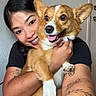arms, brown_and_white, closeup, companion, corgi, cute, dog, ears, fur, happy, hugging, indoors, person, pet, photography, portrait, smiling, tattoo, tongue_out, woman