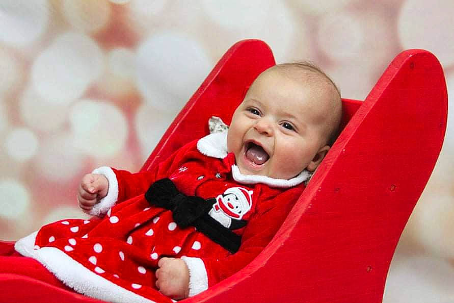 Ambre a rejoint le concours — aidez-le/la à gagner de superbes lots ! baby, baby_products, baby_toddler_clothing, carmine, cheek, child, comfort, event, fun, grass, happy, human_body, outerwear, people_in_nature, person, sitting, skin, sleeve, smile, toddler