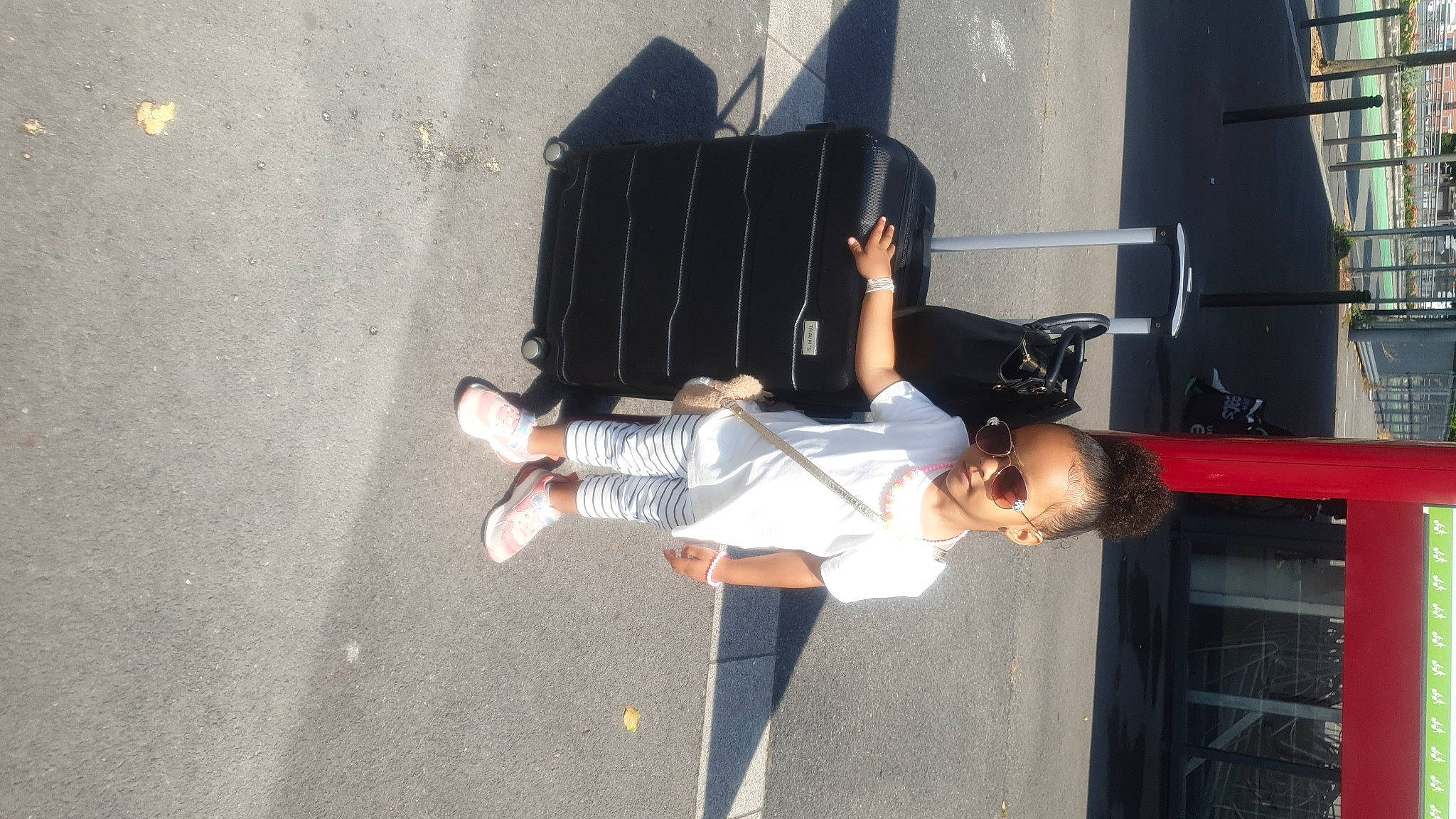 Elikya a rejoint le concours — aidez-le/la à gagner de superbes lots ! asphalt, child, entertainment, event, fun, human_leg, leisure, pedestrian, performing_arts, person, recreation, road, shadow, shorts, smile, street, thigh, toddler, tree, walking_shoe