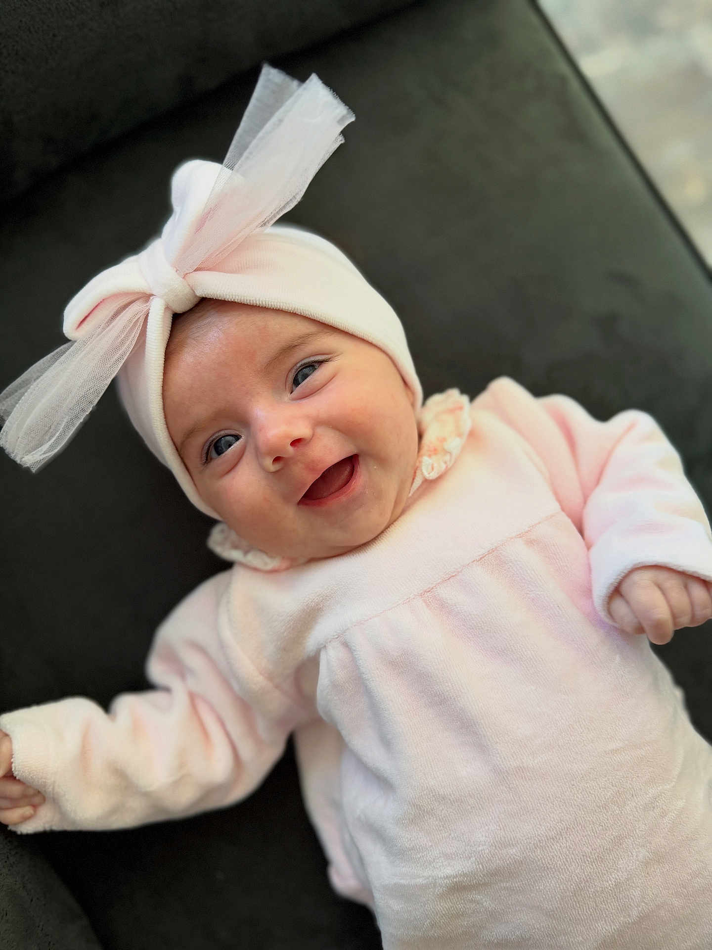 Sharell a rejoint le concours — aidez-le/la à gagner de superbes lots ! apparel, baby, bow, cheerful, child, closeup, cozy, cute, face, happy, headband, indoors, infant, lying_down, person, pink_clothing, portrait, smile, soft_texture, tulle