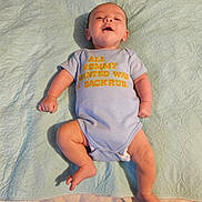 Goldie joined the competition — help win amazing prizes! baby, infant, onesie, blue_clothing, quilted_blanket, lying_down, happy, smiling, chubby_arms, chubby_legs, indoor, face, skin, footwear, text_on_clothing, relaxed, cute, child, person, infant_baby