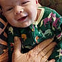 Morgan is registered to the contest to win money with this photo: baby, child, smiling, onesie, unicorn, hand, older_hand, patterned_clothing, portrait, indoor, person, cute, infant, holding, cozy, closeup, face, happy, apparel, resting
