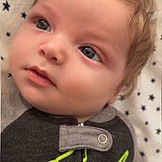 Eric joined the competition — help win amazing prizes! baby, infant, child, face, blue_eyes, light_hair, clothing, onesie, blanket, star_pattern, portrait, close_up, cute, young, toddler, sleeping_area, soft_lighting, indoor, calm, curious