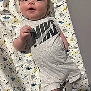 Eric joined the competition — help win amazing prizes! baby, infant, child, blanket, clothing, nike, socks, pattern, smiling, face, cute, laying, indoor, young, person, text_on_clothing, happy, head, closeup, soft