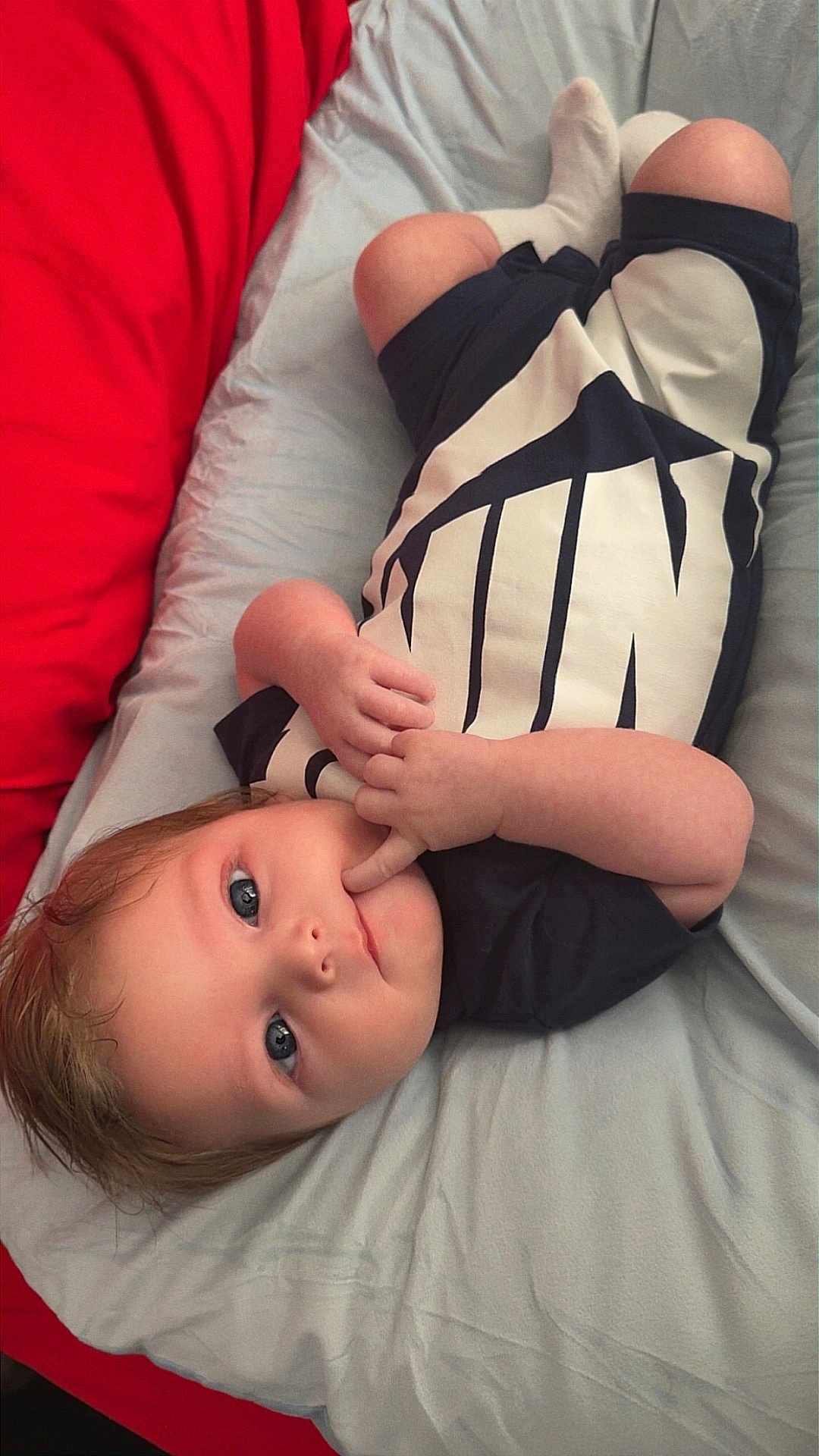 Eric joined the competition — help win amazing prizes! baby, infant, child, lying_down, bed, bedding, blanket, pillow, clothing, black_and_white, red, gray, face, hands, skin, cute, young, person, indoors, portrait