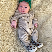 Enéa a rejoint le concours — aidez-le/la à gagner de superbes lots ! baby, infant, newborn, headwrap, green_headband, onesie, knit_onesie, buttons, booties, leopard_print, faux_fur_blanket, beige_background, portrait, close_up, face, eyes_open, curious_expression, small_hands, cozy, soft_texture