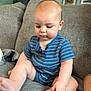 Jaxson is registered to the contest to win money with this photo: baby, barefoot, blue_romper, child, couch, curious, family_photos, furniture, gray_couch, home, indoor, infant, person, plush, portrait, sitting, soft_lighting, striped_clothing, toes, wall_art