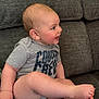 Jaxson is registered to the contest to win money with this photo: baby, child, smiling, sitting, couch, gray, shirt, text, happy, face, head, skin, feet, legs, indoor, person, infant, cute, expression, portrait