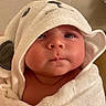 Lyla is registered to the contest to win money with this photo: newborn, baby, infant, child, portrait, face, eyes, hood, towel, wrapped, cozy, indoor, close_up, serious, expression, skin, soft_texture, warm_lighting, head, adorable