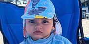 Thiago Armando joined the competition — help win amazing prizes! beach, beach_chair, blue_clothing, building, casual, child, daytime, hat, outdoor, palm_trees, person, portrait, relaxed, sand, summer, sun_hat, sun_protection, toddler, vacation, young_child