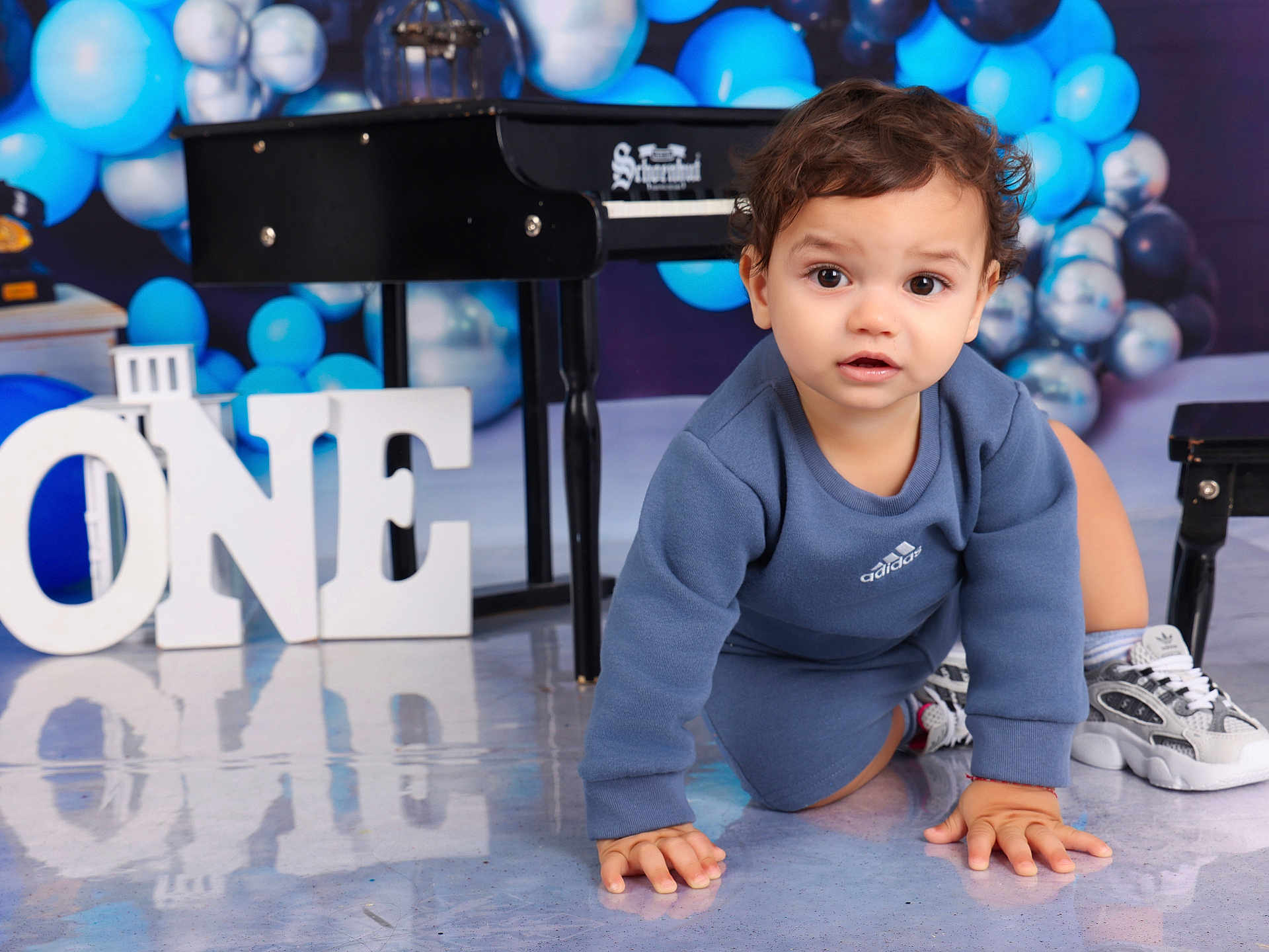 Thiago Armando is registered to the contest to win money with this photo: balloons, birthday, blue, celebration, child, clothing, crawling, cute, floor, happy, indoor, letters, number_one, piano, portrait, reflection, silver, sneakers, toddler, young
