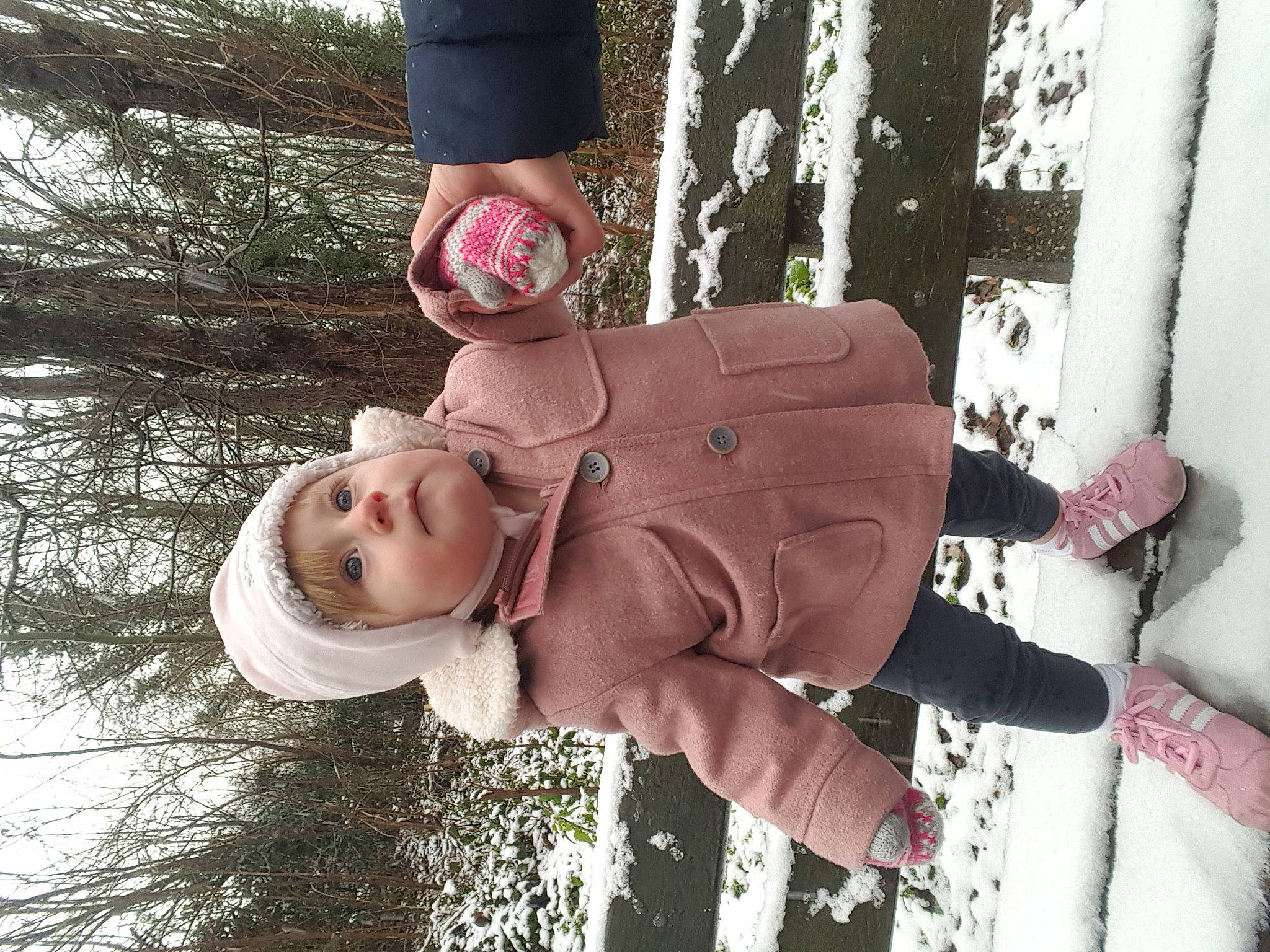 Maëlys participe au concours pour gagner de l'argent avec cette photo : arm, child, curtain, freezing, fun, gesture, grass, hand, happy, headwear, people_in_nature, person, pink, plant, sitting, snow, toddler, tree, water, window