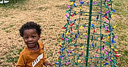 Joab joined the competition — help win amazing prizes! bench, building, car, child, colorful_lights, daytime, fun, grass, holiday_lights, outdoor, park, person, playground, shorts, sky, smiling, sneakers, sweatshirt, toddler, tree