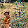 Joab joined the competition — help win amazing prizes! toddler, child, grass, outdoor, holiday_lights, colorful_lights, sweatshirt, shorts, sneakers, building, car, tree, sky, bench, playground, smiling, person, daytime, park, fun