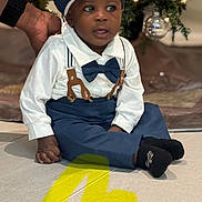 Joab joined the competition — help win amazing prizes! toddler, child, boy, sitting, clothing, bow_tie, suspenders, hat, christmas_tree, ornaments, hand, floor, indoor, holiday, decoration, portrait, smile, person, cute, baby