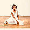 Jemima joined the competition — help win amazing prizes! child, girl, white_dress, smiling, sitting, wooden_floor, portrait, hair_accessory, elegant, young, studio, pose, flooring, happy, person, indoors, fashion, cute, childhood, single_subject