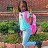 Jemima is registered to the contest to win money with this photo: child, girl, backpack, hello_kitty, peace_sign, pose, jeans, boots, braids, garden, flowers, brick_wall, sidewalk, outdoor, greenery, playful, casual_clothing, young, cute, expression