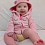 baby, infant, pink_hoodie, smiling, sitting, couch, soft_fabric, cute, child, hood, happy, face, legs, feet, zipper, indoor, light_skin, casual_clothing, cozy, portrait