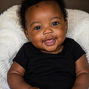 Jaheim joined the competition — help win amazing prizes! baby, infant, smiling, black_onesie, fluffy_blanket, cute, portrait, child, happy, skin, face, eyes, hands, sitting, indoor, closeup, adorable, young, person, cozy