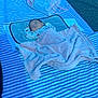baby, blanket, sleeping, outdoor, striped_blanket, mesh_bag, toys, pink_blanket, child, peaceful, soft_texture, resting, infant, cozy, relaxing, head, face, small_hands, blue, white