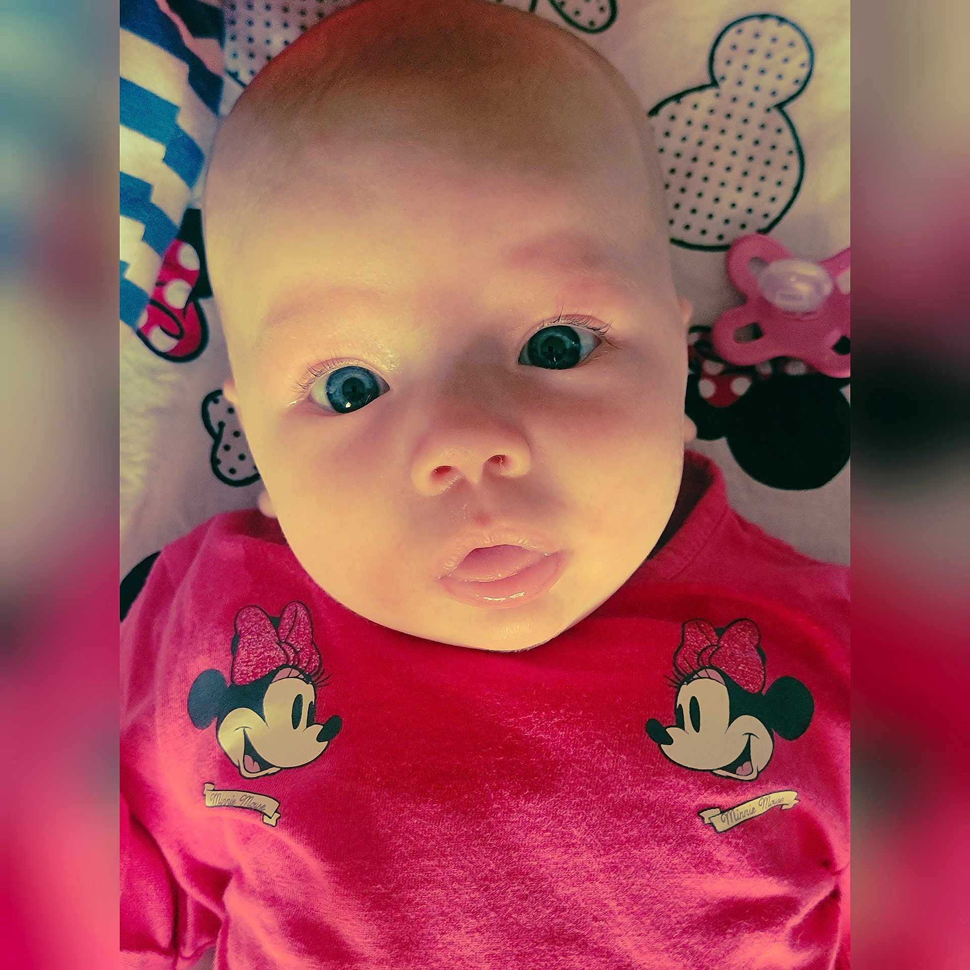 Mya participe au concours pour gagner de l'argent avec cette photo : baby, infant, face, eyes, mouth, pink_shirt, minnie_mouse, pacifier, blanket, cute, child, portrait, closeup, expression, lying_down, skin, head, clothing, pattern, adorable