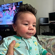 Tristan joined the competition — help win amazing prizes! baby, infant, onesie, turtle_pattern, hand, face, cheeks, hair, cute, closeup, portrait, living_room, television, monitor, blanket, couch, holding, soft_lighting, expression, sitting