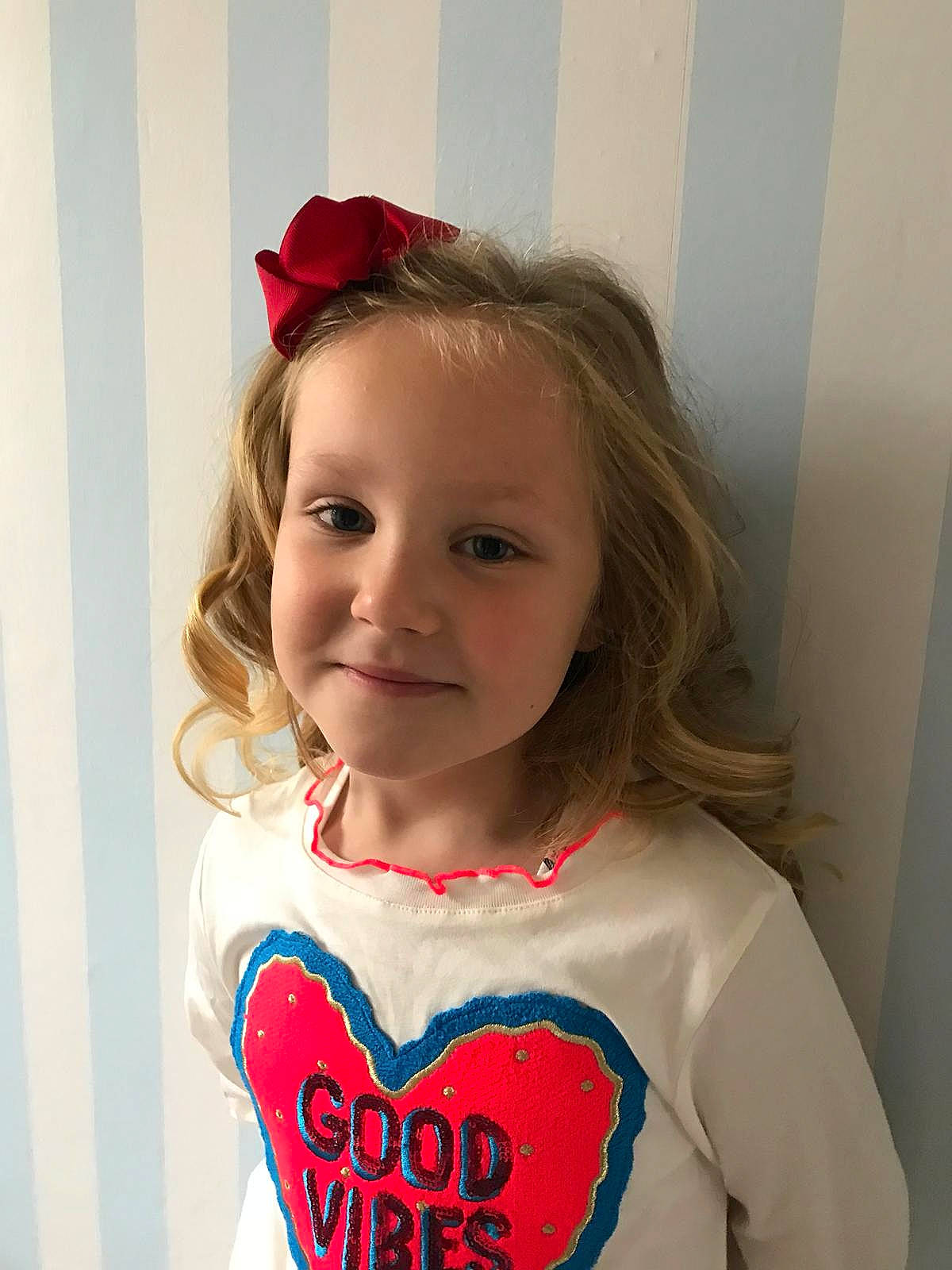 Dolly is registered to the contest to win money with this photo: brown_hair, child, day, design, ear, girl, hair_accessory, hairstyle, headband, human_hair_color, joy, long_hair, pattern, person, product, red, shoulder, skin, smile, textile