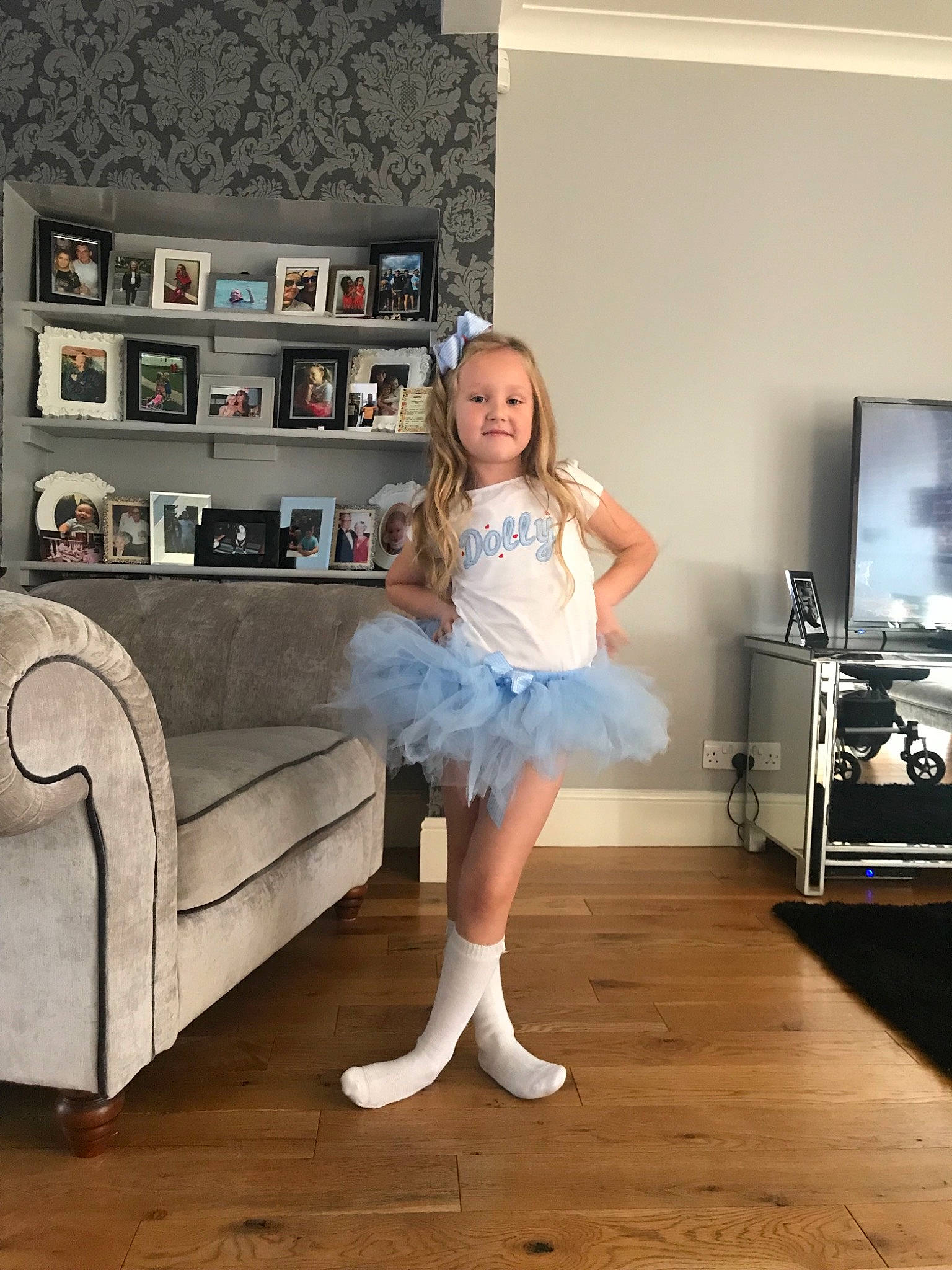 Dolly is registered to the contest to win money with this photo: ballet_tutu, costume, floor, flooring, furniture, girl, leg, person, room, shoe, shoulder, table