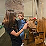 Ezra joined the competition — help win amazing prizes! woman, toddler, child, telephone, vintage, wooden, indoor, historical_map, glasses, black_shirt, blue_pajamas, shoe, holding, curious, playful, cord, old_fashioned, furniture, smile, interaction