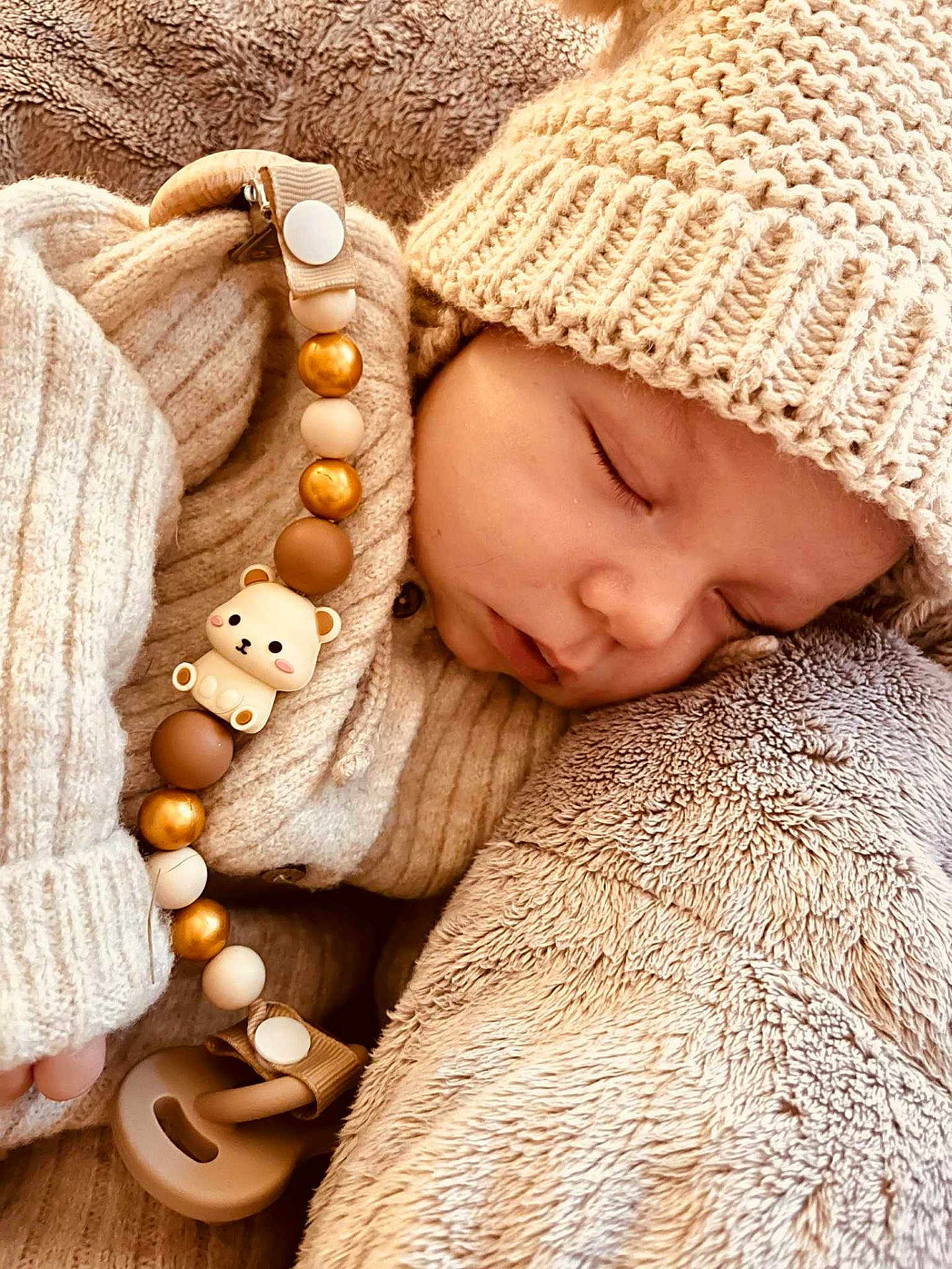 Lio participe au concours pour gagner de l'argent avec cette photo : baby, sleeping, knit_hat, knit_sweater, pacifier, beads, bear_charm, plush_blanket, cozy, soft_texture, infant, cute, child, resting, warm_clothing, closeup, portrait, peaceful, indoors, comfort