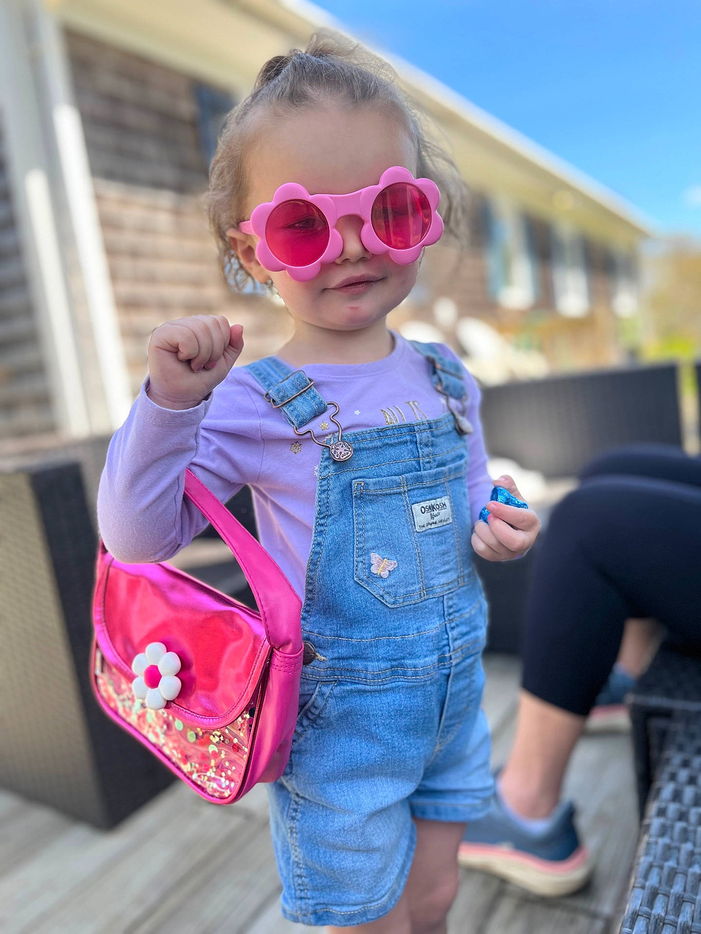 Olivia is registered to the contest to win money with this photo: accessory, bag, blue_sky, casual, child, cute, daylight, denim_overalls, fashion, girl, handbag, happy, outdoor, person, pink, playful, portrait, smile, summer, sunglasses