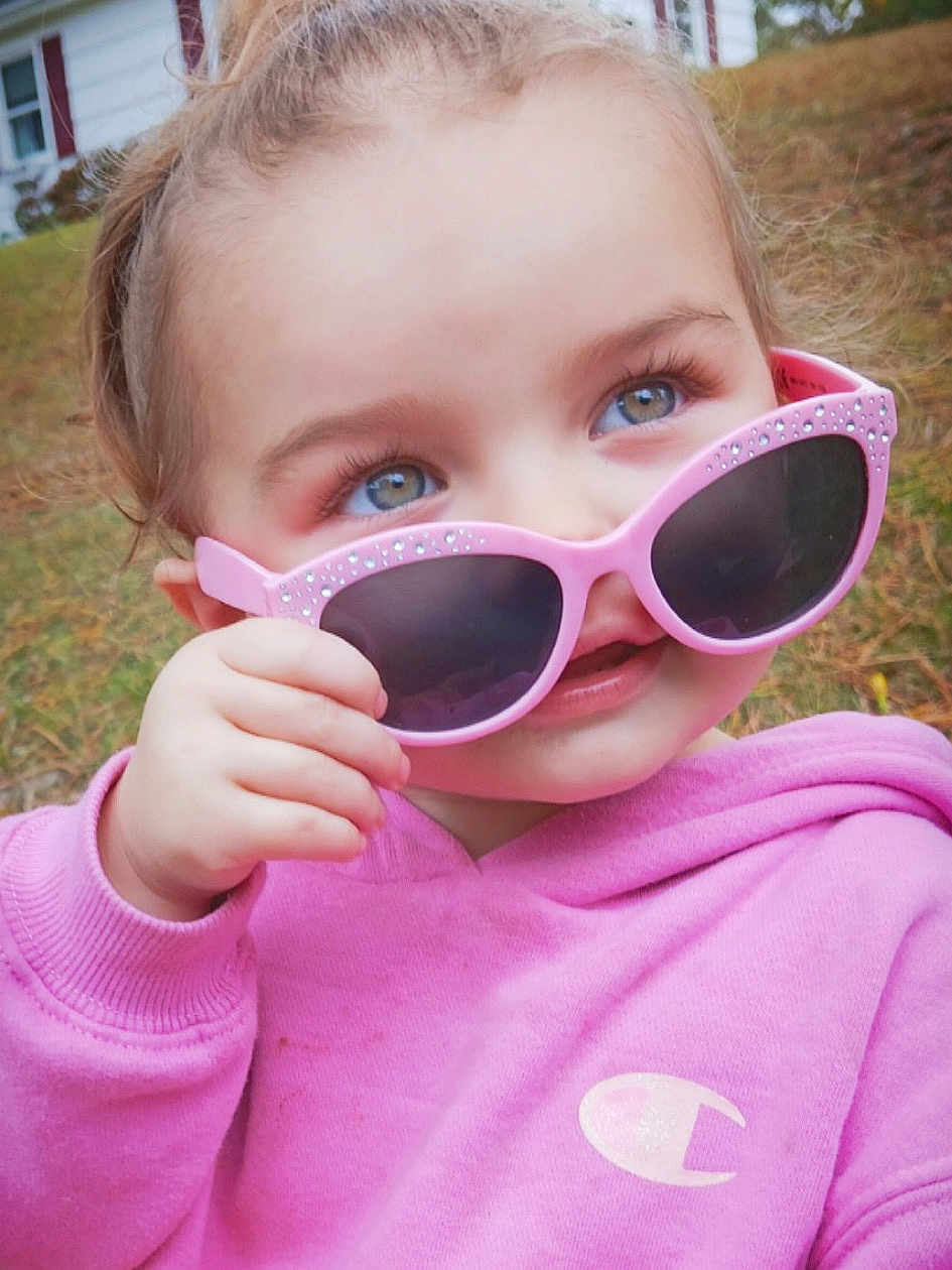 Olivia joined the competition — help win amazing prizes! child, toddler, sunglasses, pink, hoodie, outdoor, grass, face, hand, blue_eyes, casual_clothing, cute, person, portrait, young_child, fashion, fall, nature, expression, fun