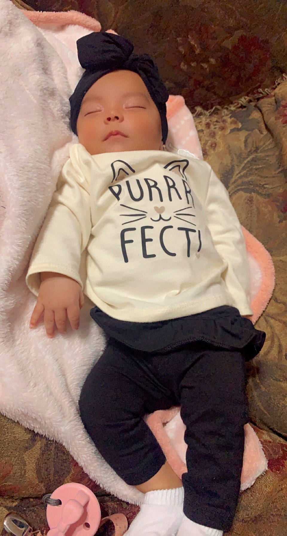 Leilany is registered to the contest to win money with this photo: abdomen, baby, baby_sleeping, baby_toddler_clothing, cap, child, comfort, eye, face, head, headgear, jersey, linens, person, personal_protective_equipment, sleeve, sportswear, t_shirt, thigh, toddler