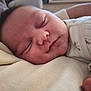 baby, sleeping, close_up, face, infant, peaceful, soft_skin, resting, newborn, cute, portrait, child, young, cozy, blanket, clothing, indoors, human, sleep, relaxation