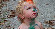 Adam joined the competition — help win amazing prizes! artistic, bare_chest, blue_eyes, child, colorful, creative, curly_hair, face_paint, gravel, leaves, messy, nature, outdoor, paint, playful, portrait, serious_expression, skin, summer, toddler