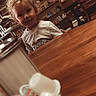 Adam is registered to the contest to win money with this photo: blurred_foreground, child, cozy, curly_hair, curly_hair_child, cute, decor, furniture, indoor, interior, mugs, person, salt_shaker, shelf, smile, table, toddler, warm_lighting, wooden_table, young_child