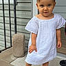 toddler, child, white_dress, pink_sandals, bows, porch, curious, hair_accessories, footwear, outdoor, sidewalk, railing, bracelet, person, young_child, standing, smiling, cute, fashion, summer