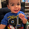 Jayden joined the competition — help win amazing prizes! toddler, child, smiling, high_chair, blue_shirt, lightning_mcqueen, curly_hair, indoor, person, face, happy, cute, young_child, seated, table, playful, clothing, portrait, expression, baby