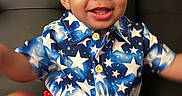 Jayden joined the competition — help win amazing prizes! baby, blanket, blue_shirt, buttoned_shirt, child, clothing, couch, curly_hair, cute, foot, happy, indoor, person, portrait, red_shorts, sitting, skin, smiling, stars_pattern, toddler