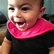 Armani joined the competition — help win amazing prizes! baby, child, infant, smiling, laughing, portrait, close_up, face, eyes, open_mouth, pink_bib, black_clothing, earring, sitting, indoors, home, couch, happy, adorable, photography
