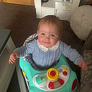 Jaxon joined the competition — help win amazing prizes! baby, blue_sweater, cabinet, carpet, carpeted_floor, child, cute, drool, furniture, happy, home, indoor, person, play, playtime, smiling, toy_buttons, toy_car, walker, young_child