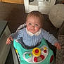 baby, blue_sweater, cabinet, carpet, carpeted_floor, child, cute, drool, furniture, happy, home, indoor, person, play, playtime, smiling, toy_buttons, toy_car, walker, young_child