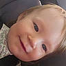 Allison Grace is registered to the contest to win money with this photo: child, toddler, blond_hair, blue_eyes, smiling, face, portrait, close_up, selfie, indoor, seated, floral_fabric, dark_background, cozy, happy, looking_at_camera, young_person, cheeks, eyes, photography