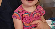 Allison Grace is registered to the contest to win money with this photo: toddler, child, baby, portrait, smiling, happy, sitting, indoor, adult, parent, holding, rainbow, stars, pink_clothing, short_sleeves, blonde_hair, face, eyes, couch, diaper