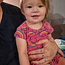 toddler, child, baby, portrait, smiling, happy, sitting, indoor, adult, parent, holding, rainbow, stars, pink_clothing, short_sleeves, blonde_hair, face, eyes, couch, diaper